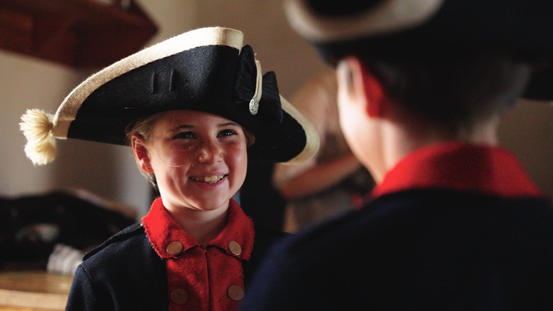 Kids dressed up in period clothing smiling