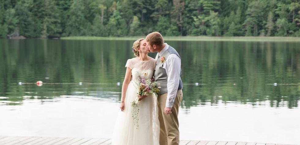  flower girl and ring bearer sit by a boulder.