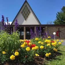 A building with tall peak and diamond shaped stained glass