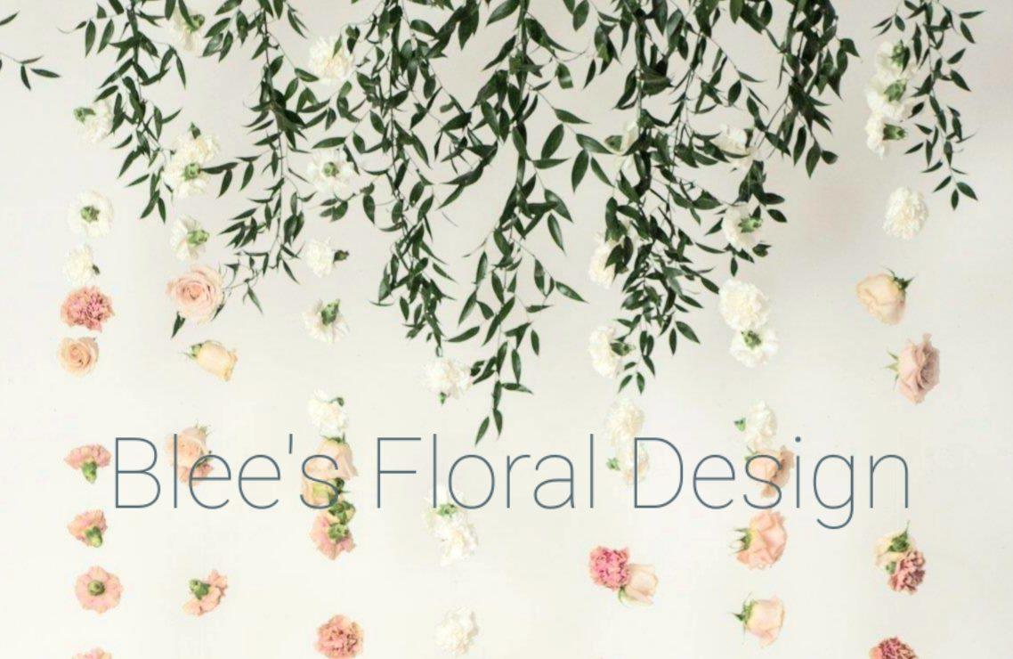 Flowers dangle by a wall over Blee's Floral Design.