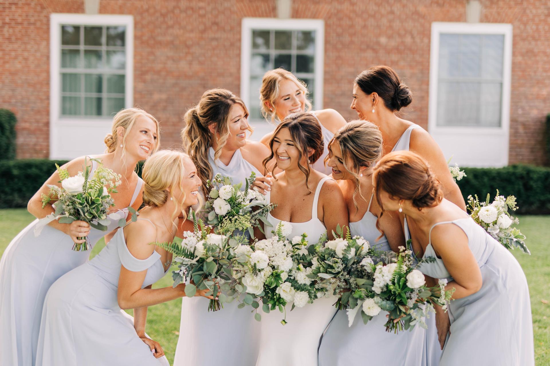 Bridesmaids holding white bouquets.