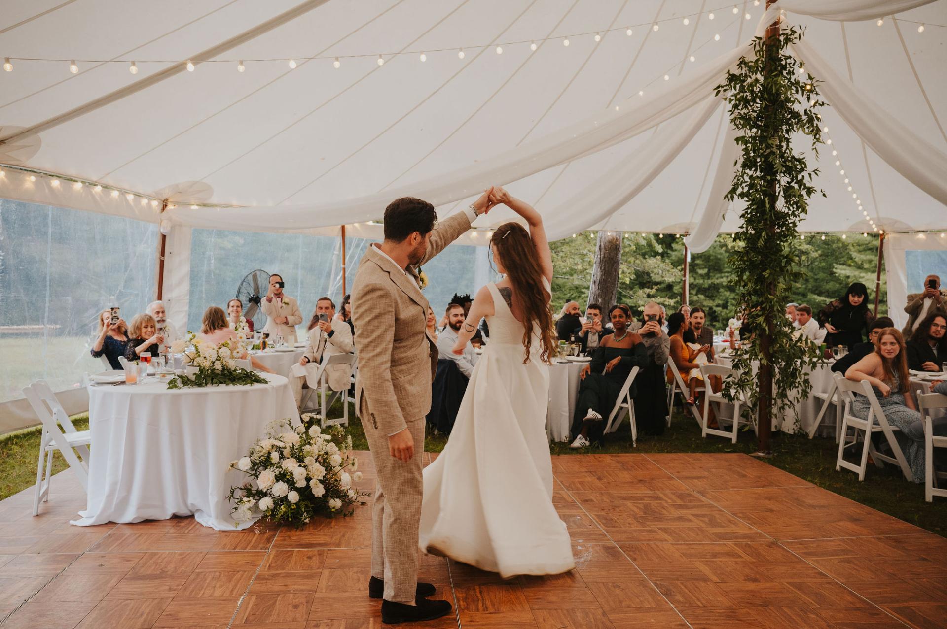 Bride and groom dance under a white tent