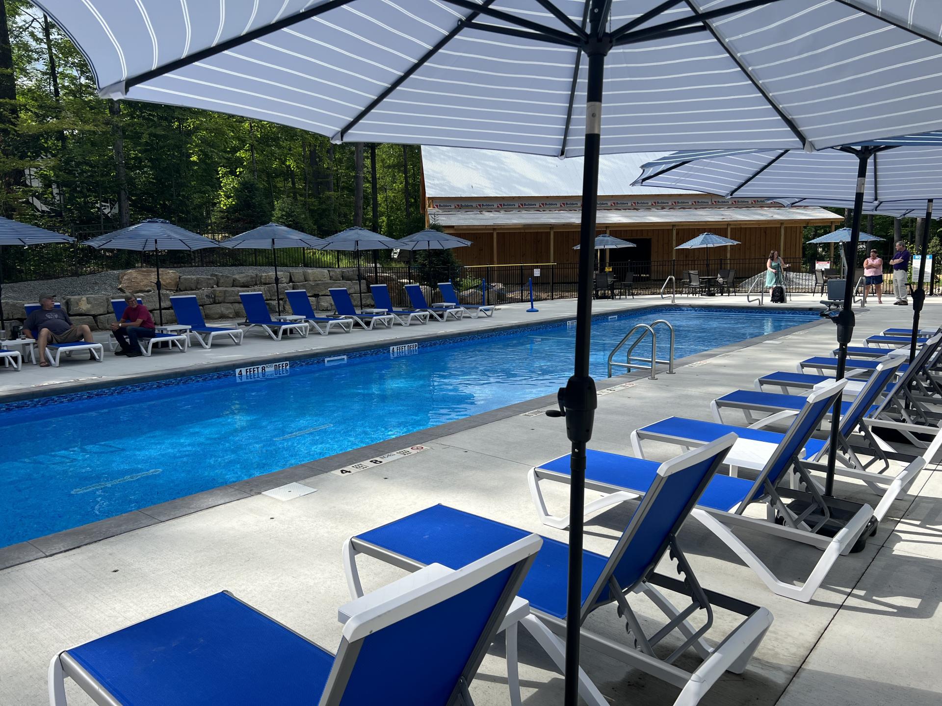 Blue sun chairs under sun umbrellas by the pool.