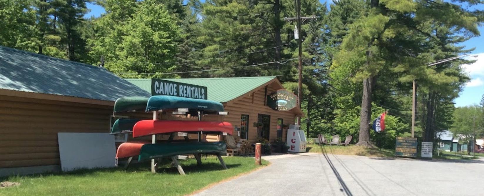A log structure with a rack for canoes out front.