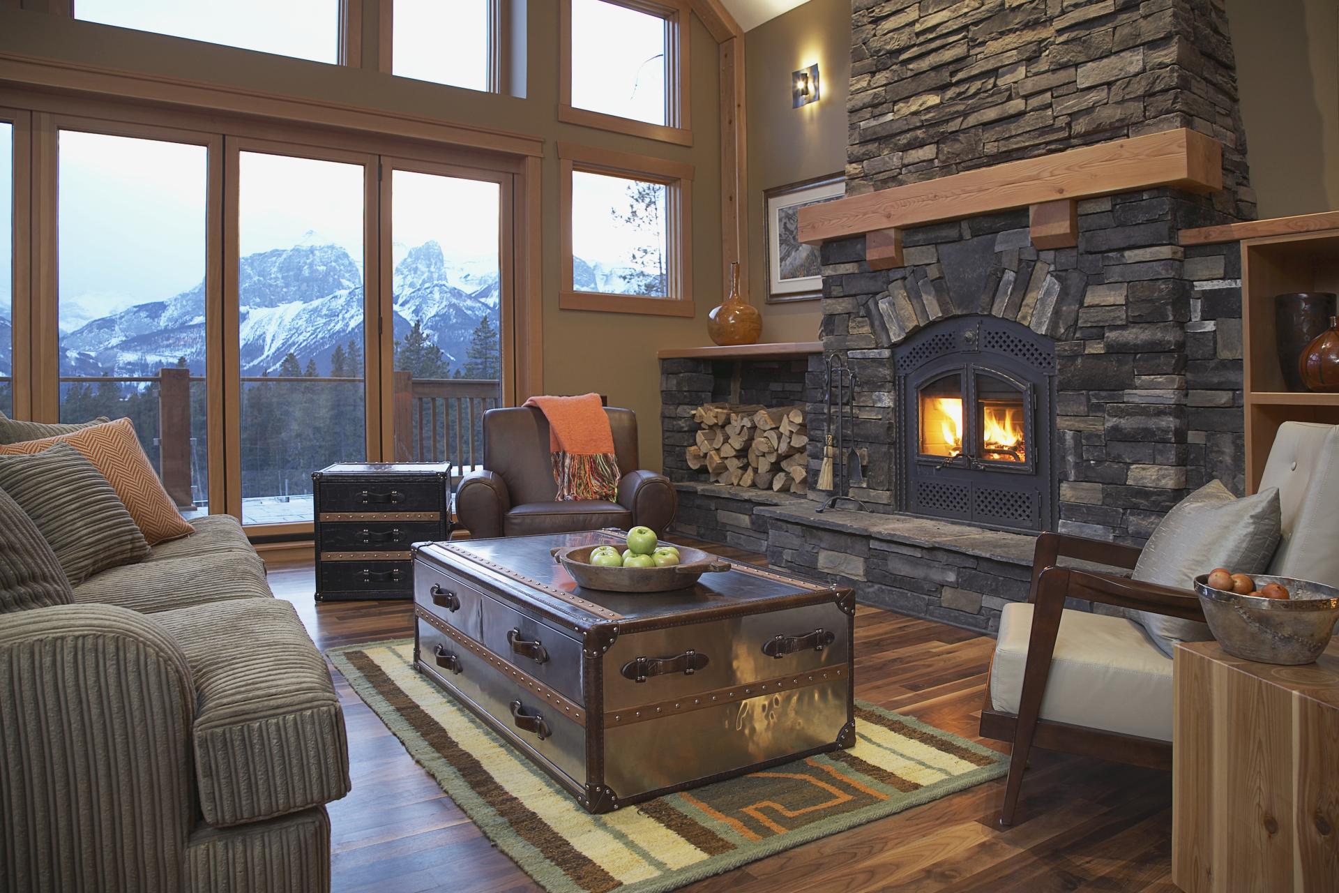 A grand living room with stone hearth and mountain views