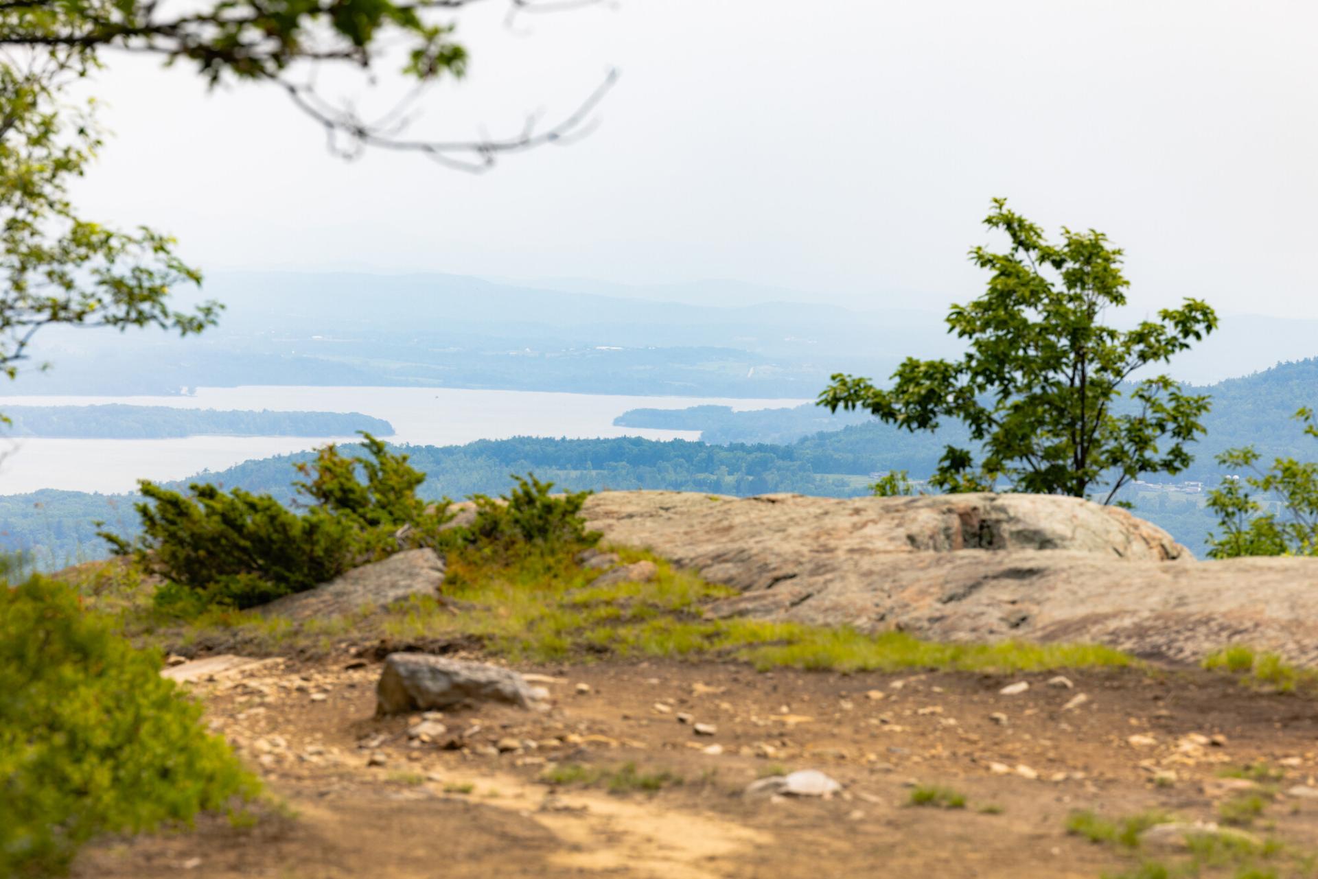 An open summit looking out towards narrow Lake Champlain.