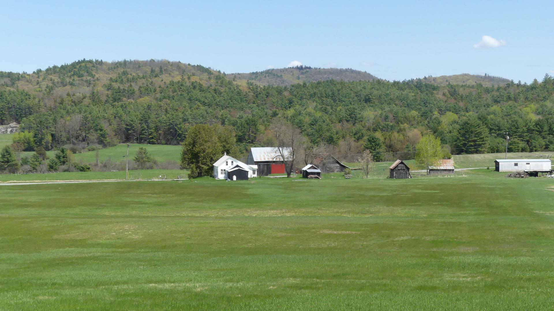 An open field with a farm in the middle. 