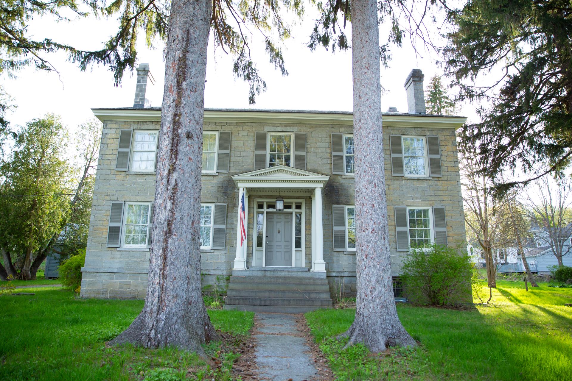 A historic building framed by two large trees