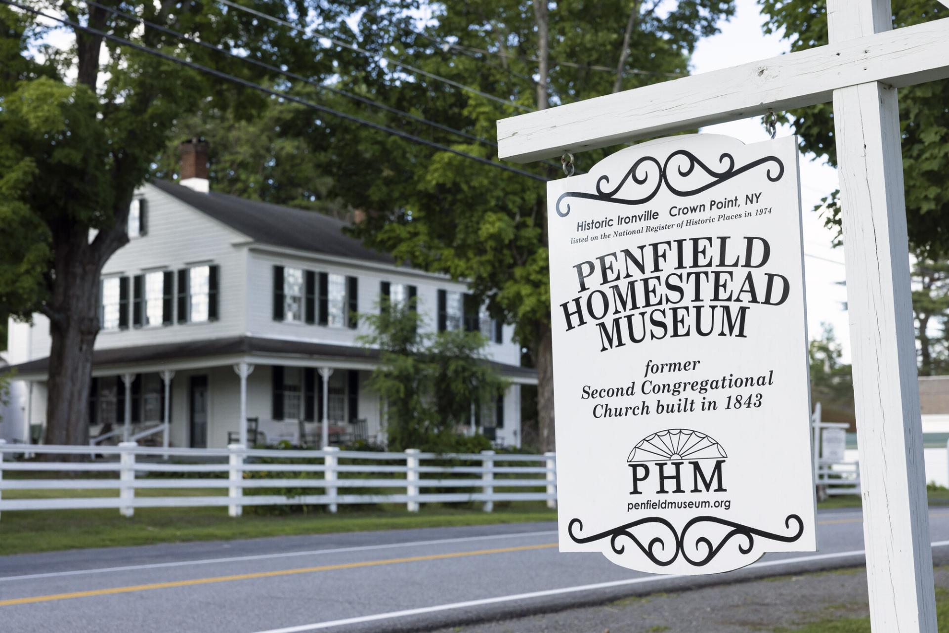 A white wooden sign for the Penfield History Museum.