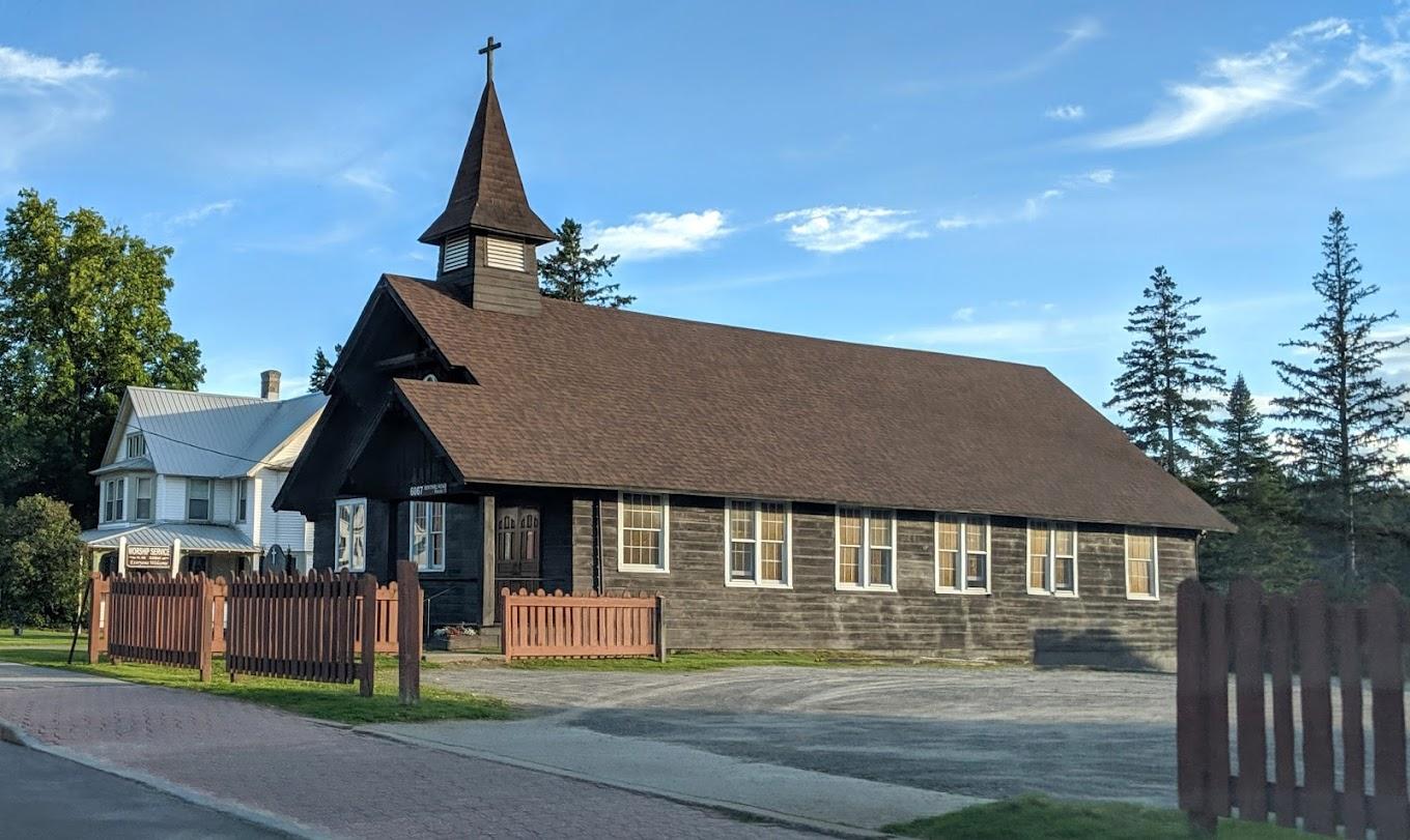 Exterior view of the log building housing Pilgrim Holiness Church in lake placid
