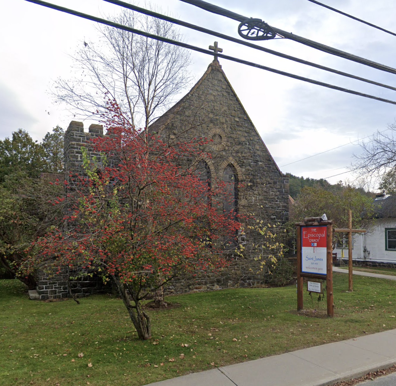 An old stone church with a flowering tree