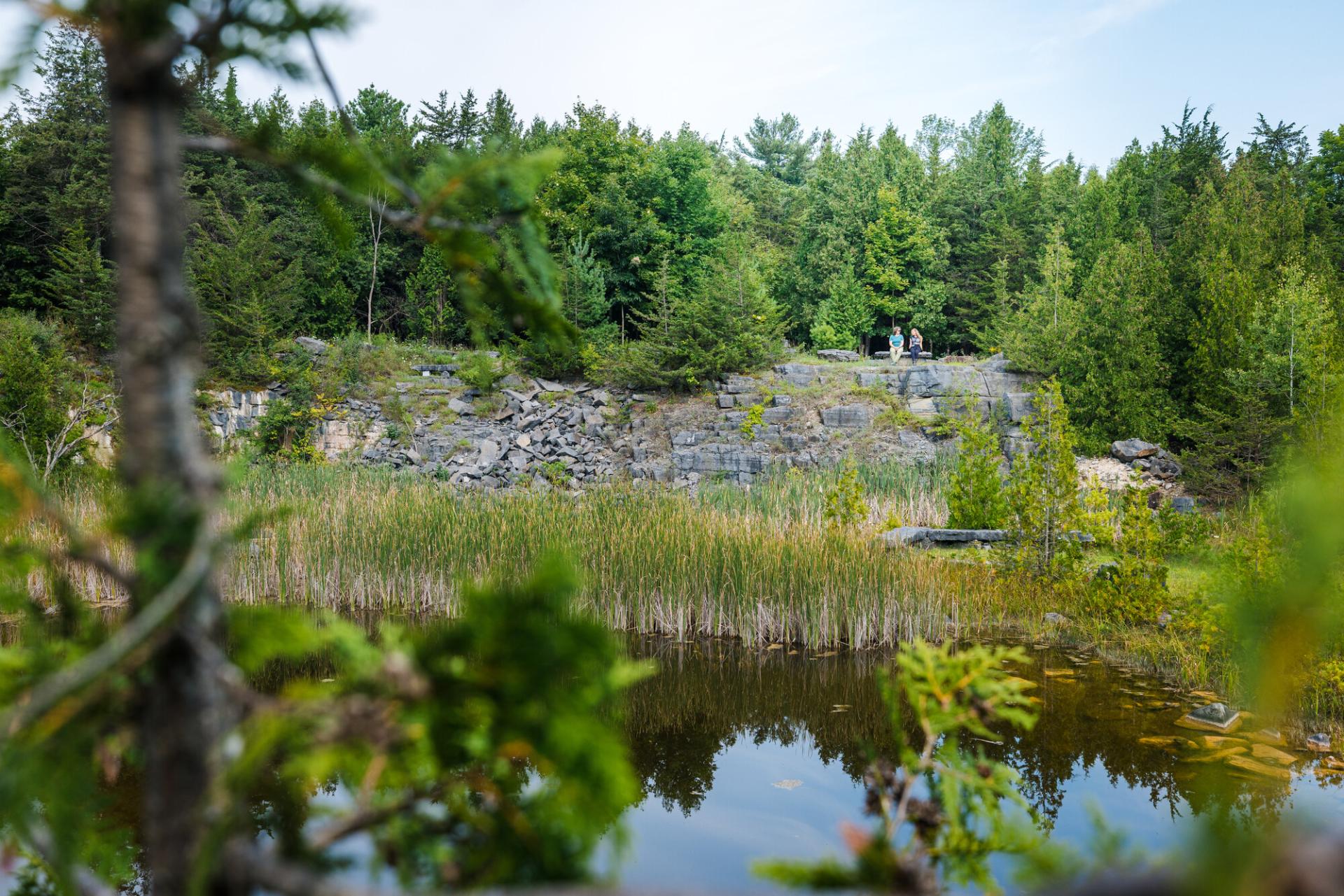 Two people on a bench above a quarry.