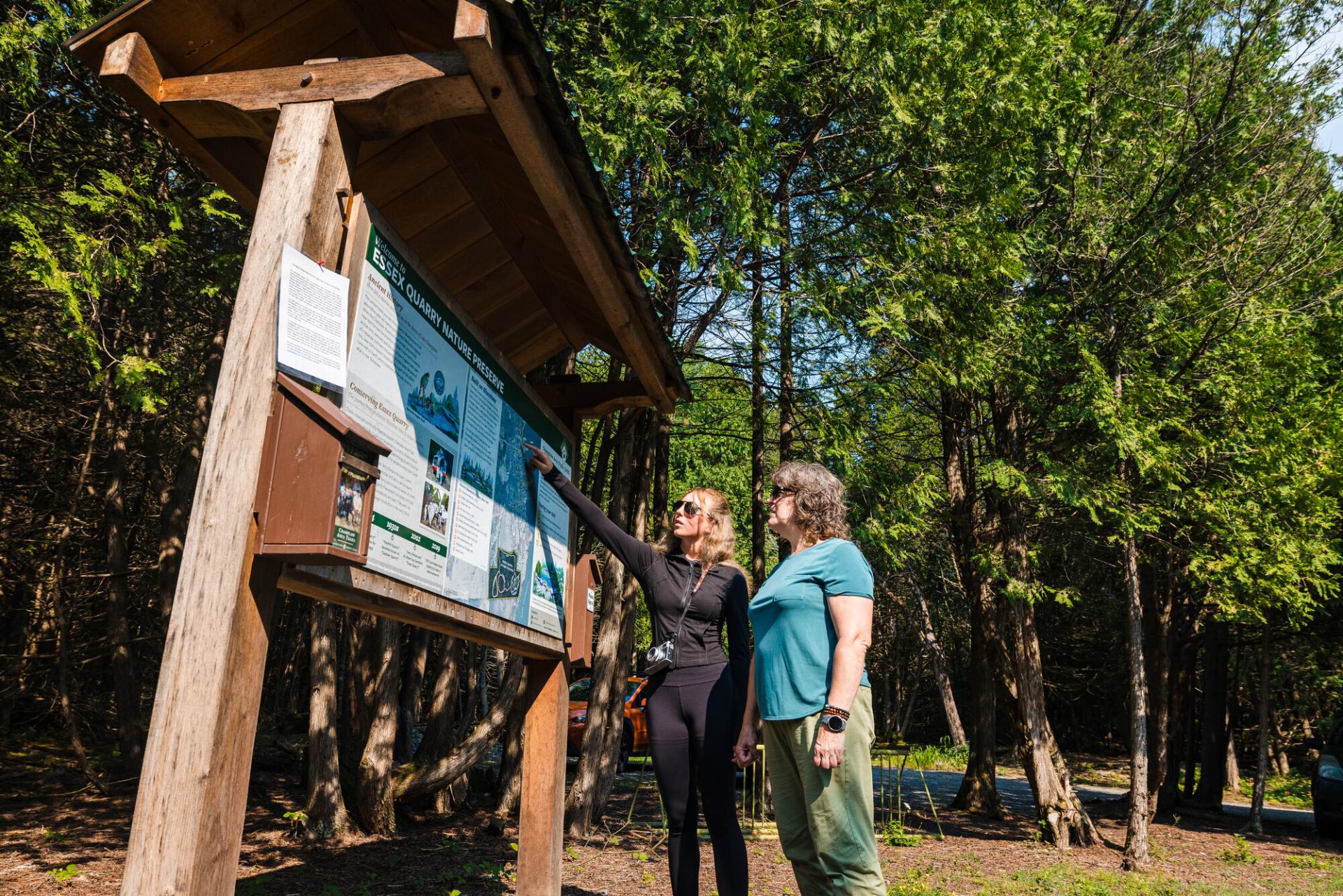 Two people at the Essex Quarry trailhead kiosk