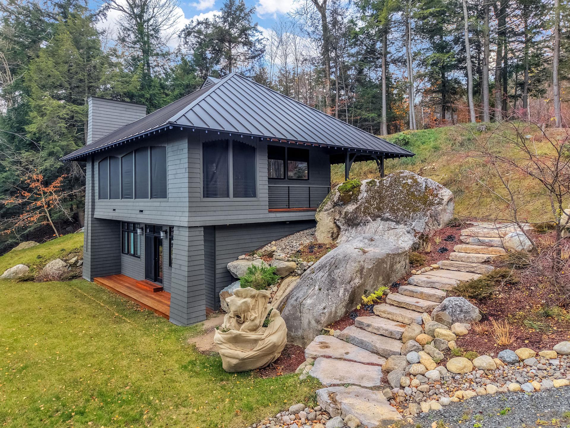 A modern grey home with metal roof and tall